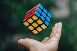 afbeelding van een opgeloste rubix cube die opgeworpen wordt
