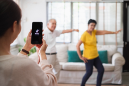 afbeelding van mensen die dansen terwij iemand een video maakt van hun op de app tiktok